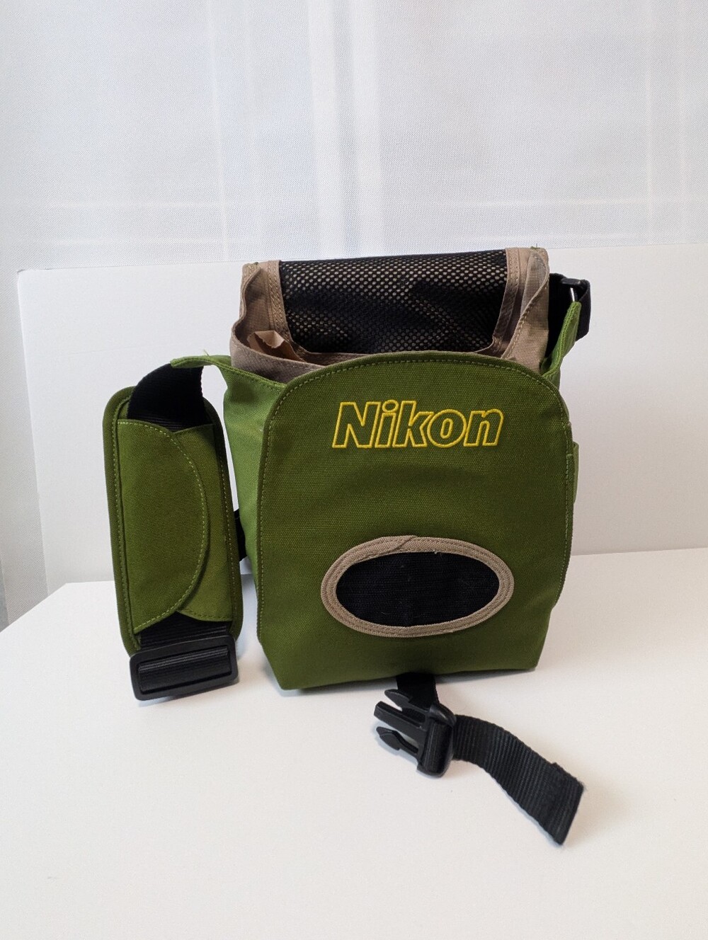Nikon Olive Green camera bag with a black zipper and adjustable strap.